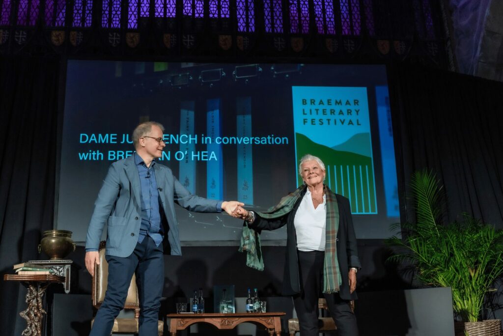 Brendan O'Hea welcoming Dame Judy Dench on stage at the Braemar Literary Festival | The Fife Arms