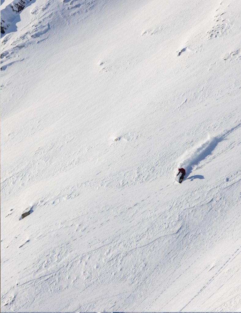 A skier coming down the snowy mountains