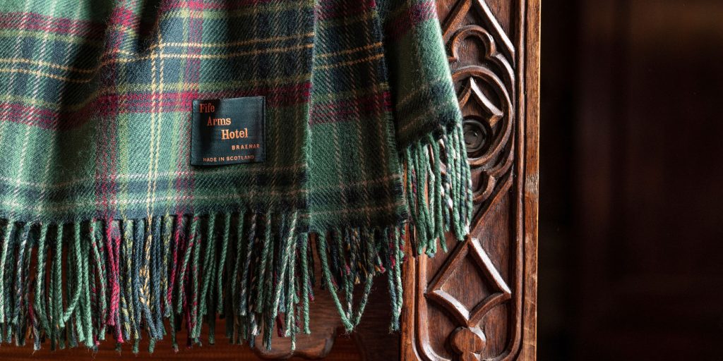 Fife Arms tartan blanket hung on the side of a bed