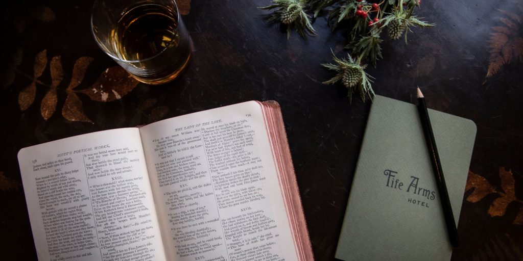 A scottish poetry book, notebook and pencil on a table at the fife arms