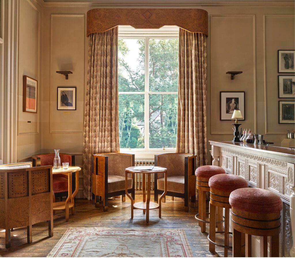Elsa's Cocktail Bar during the day, a large window in the centre, pink bar stools on the right next to the cocktail bar.