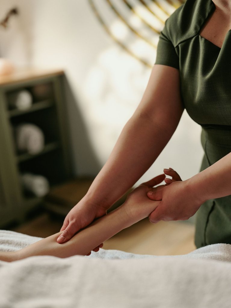A spa therapist giving an arm massage to a guest.