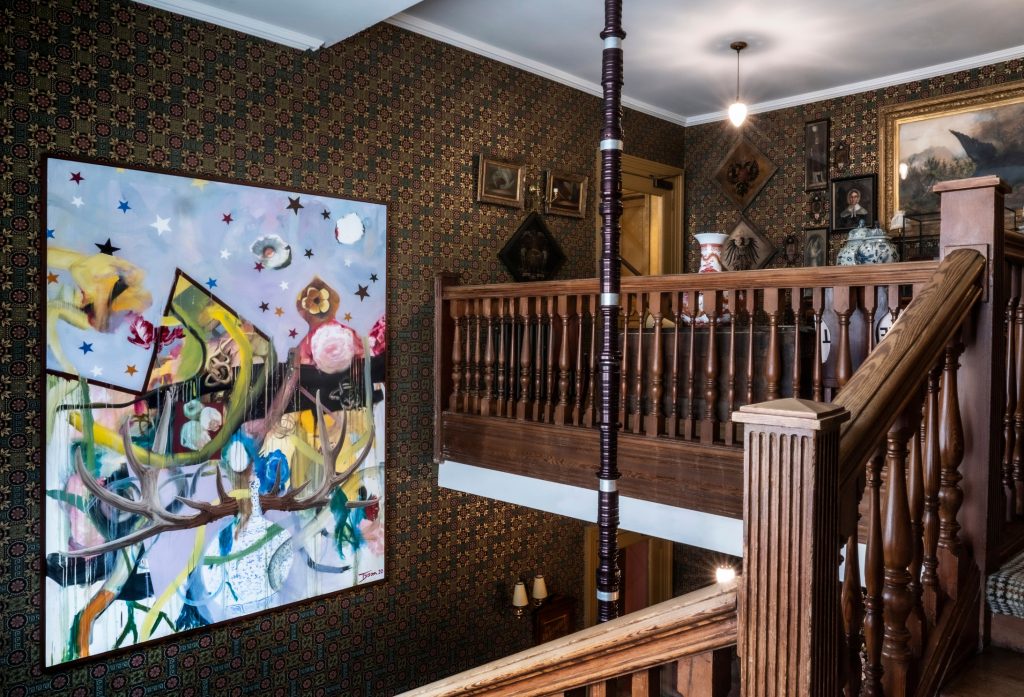 A contemporary painting hanging in a Victorian staircase