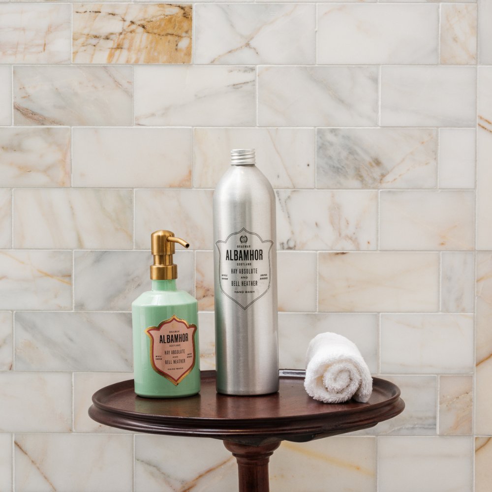 Albamhor hand wash and refill bottle on a wooden table with light beige tiles in the background.