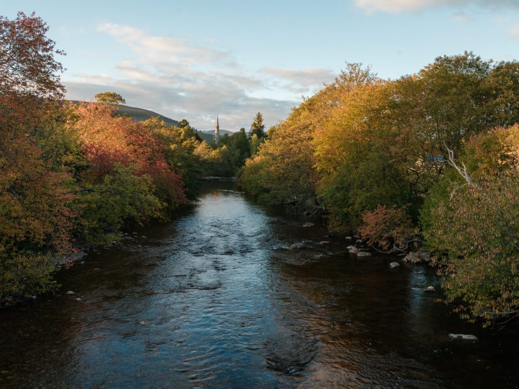 A river lined with autumnal coloured trees