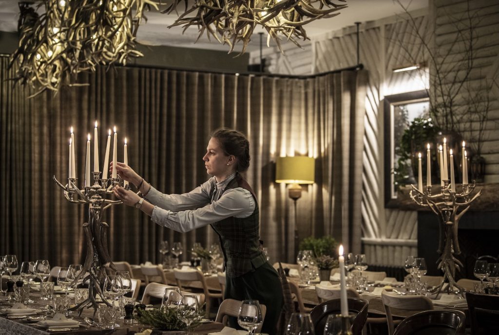 A woman lighting candles on a candelabra for an event