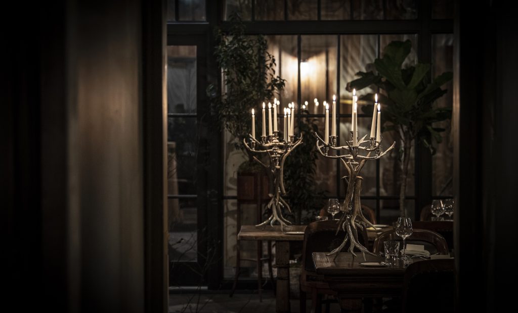 Candles lit on candelabras in a dark room for an event