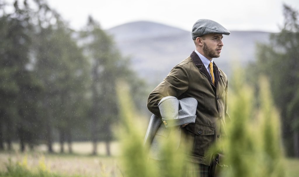 Ghillie wearing a coat with trees in the background