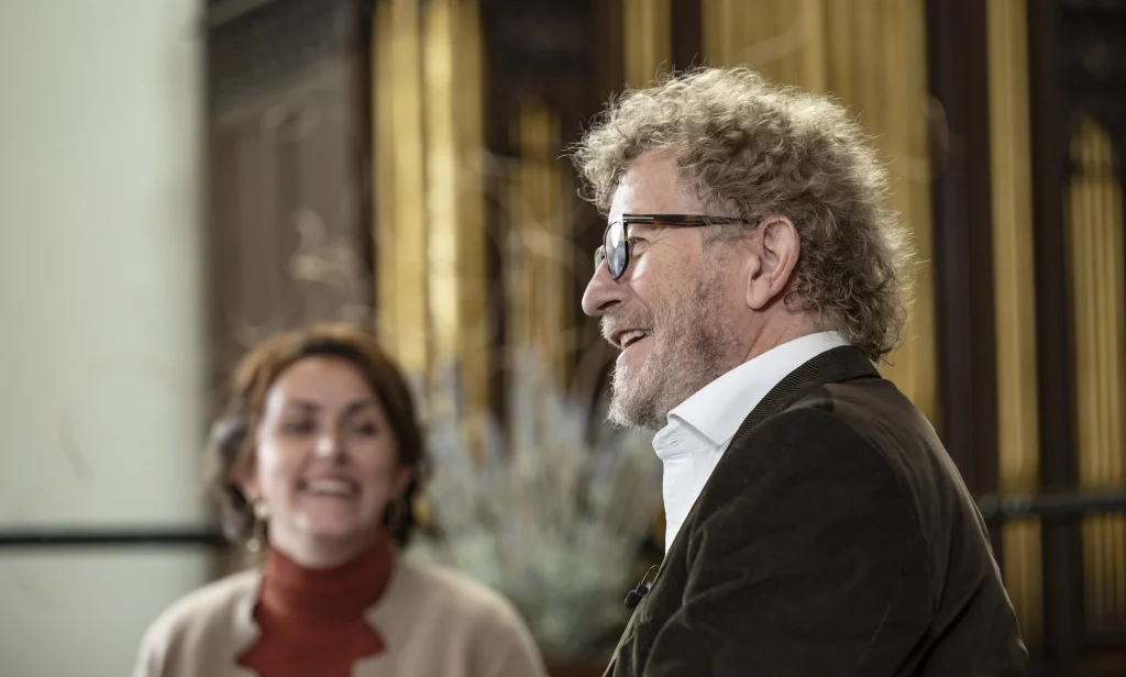 profile of man talking with a lady behind him