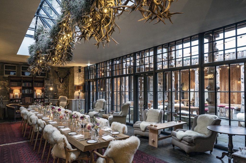 A long table with chairs covered in sheepskins in the Fog House set up for an event