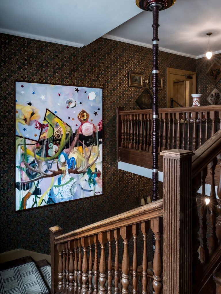 A contemporary painting hanging in a Victorian staircase