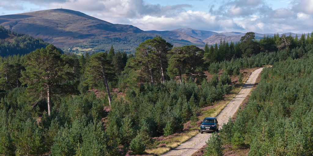 A Land Rover driving through a Highland landscape