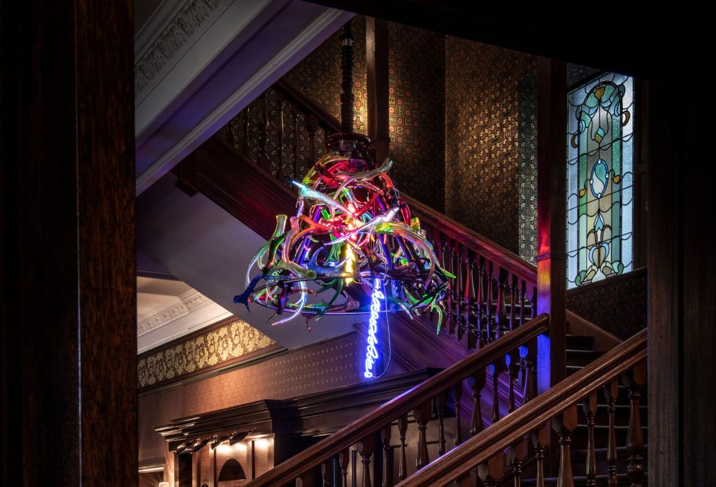 Richard Jackson's neon chandelier hanging above a staircase