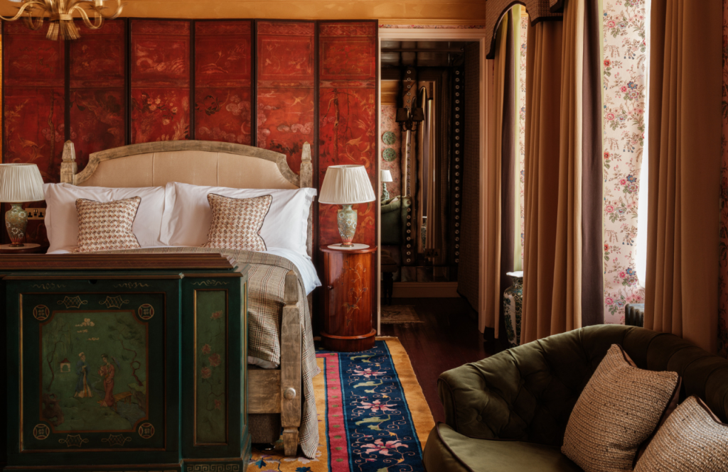 The bed in front of a painted screen in the Secret Room.