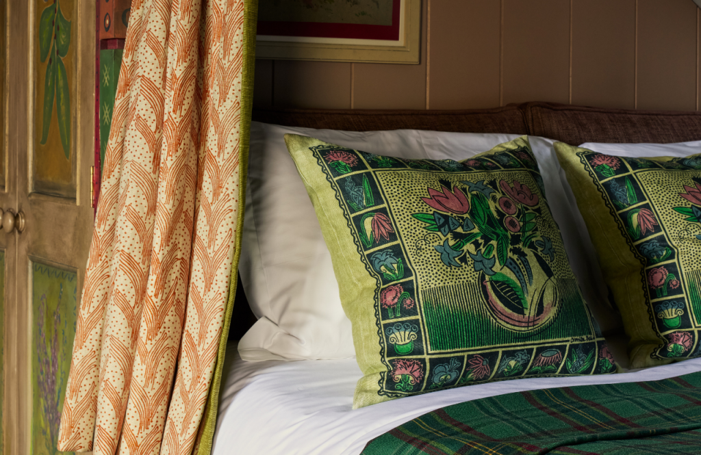 Patterned cushions and curtains on the bed in the Artist's Studio.