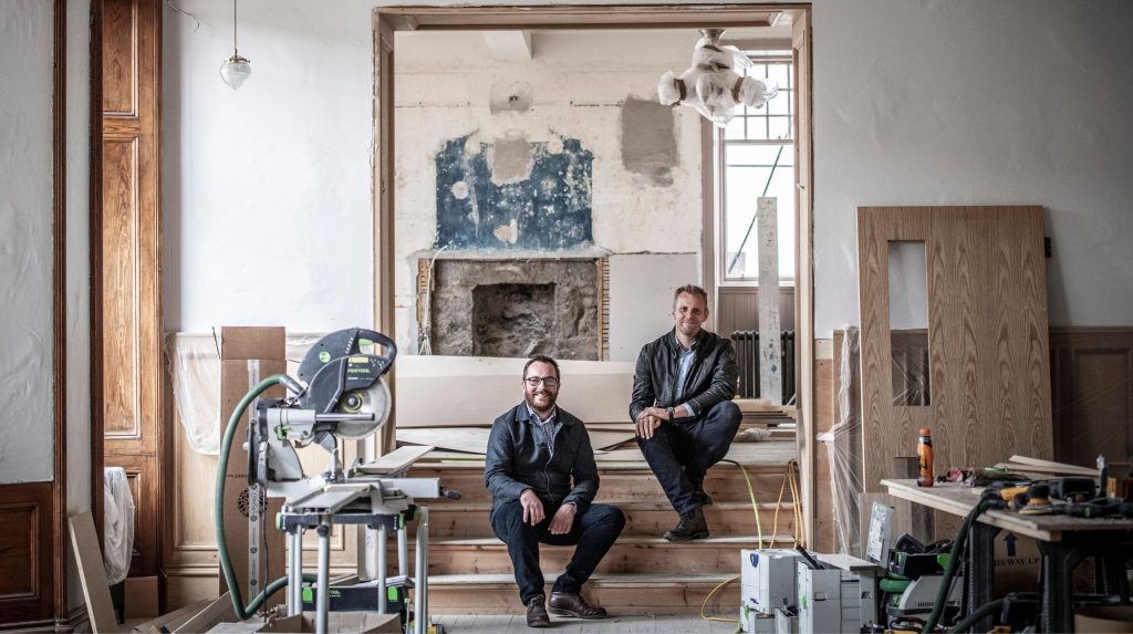 Tom and Ben Addy sitting in the Flying Stag during renovations of the Fife Arms