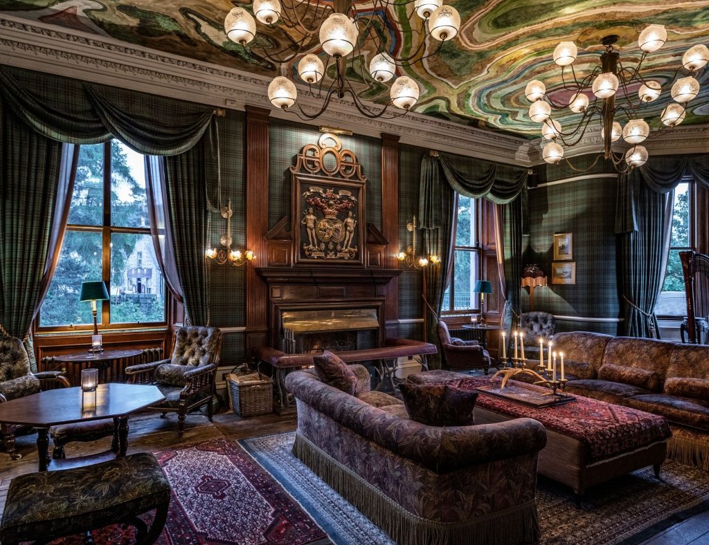 The Drawing Room with lights on and sun shining through the windows