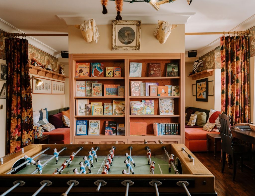 A children's play room with shelves of books and table football.
