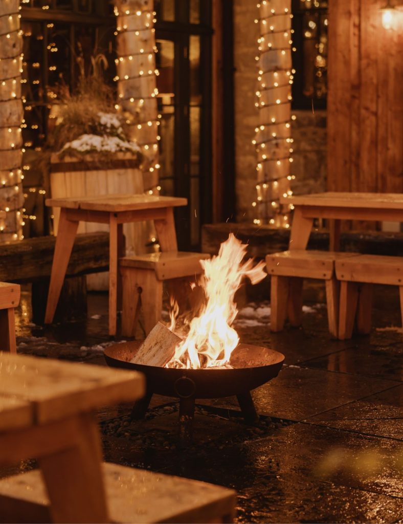 A fire burning in a fire pit in the middle of the Fife's courtyard at night.