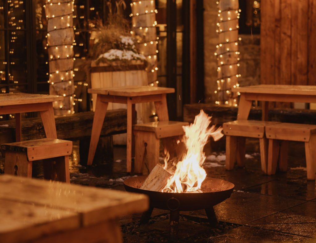 A fire burning in a fire pit in the middle of the Fife's courtyard at night.