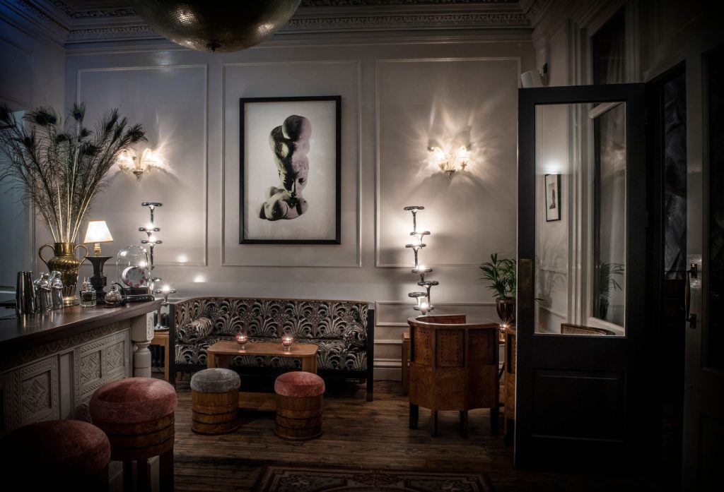 A print of a sculpture hanging in a darkly lit cocktail bar