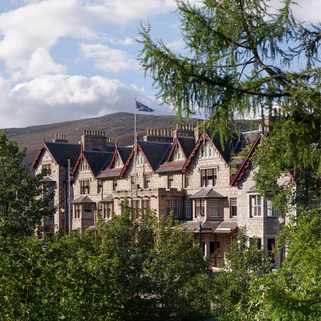 The front of the Fife Arms viewed through trees in the summer