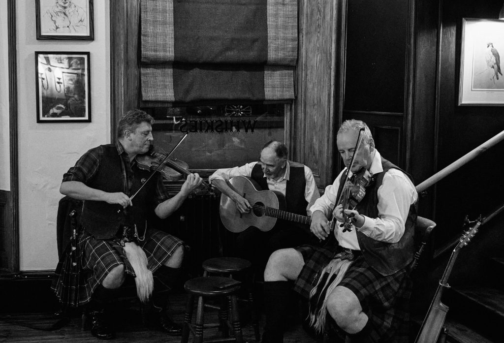 Three musicians playing folk music in The Flying Stag pub
