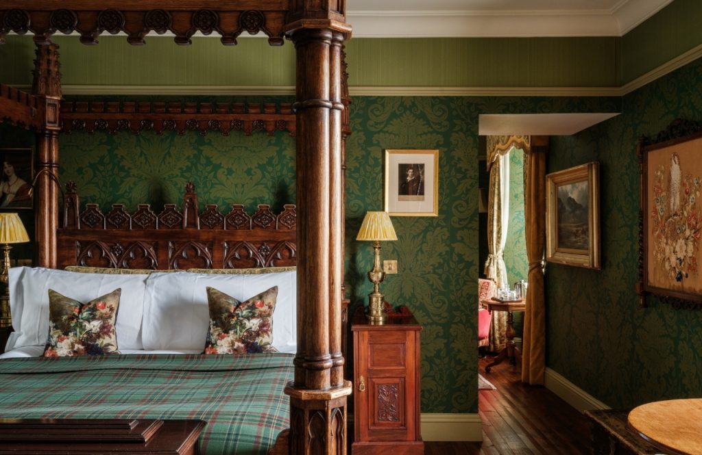 A four poster bed in an opulent green bedroom