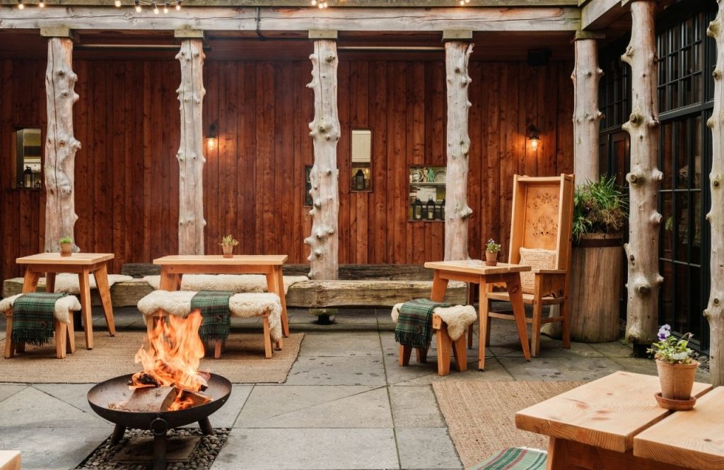Wooden seating by a fire pit in a courtyard