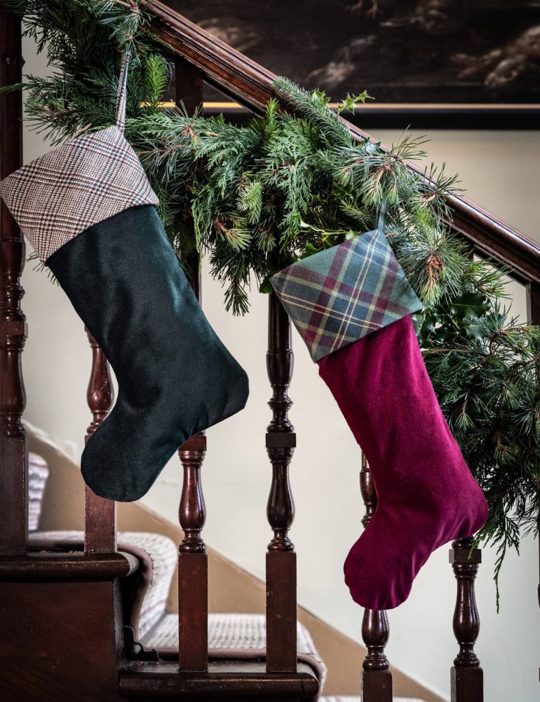 A green and red Christmas stocking hanging on a bannister.