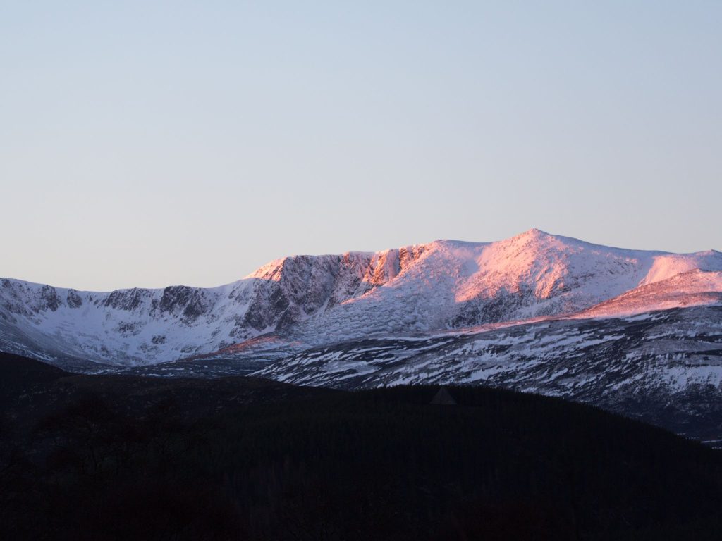 Snowy mountains in the Scottish Highlands in the pink light of dusk