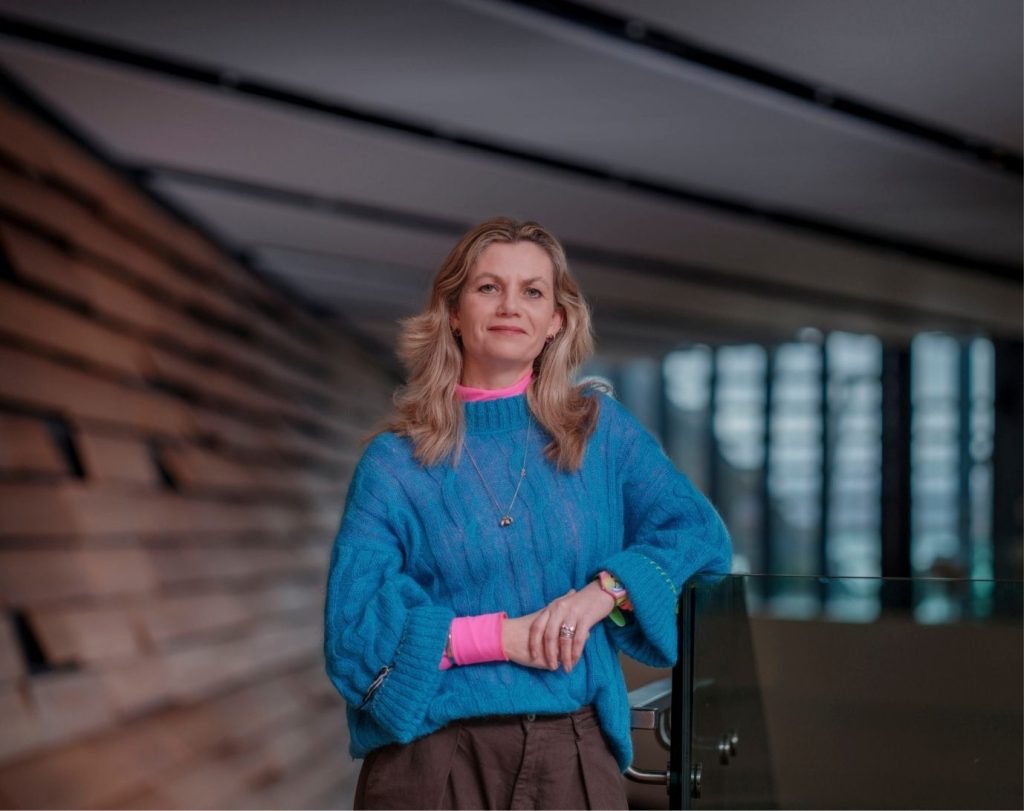 A blonde woman in a blue jumper in the V&A Dundee.