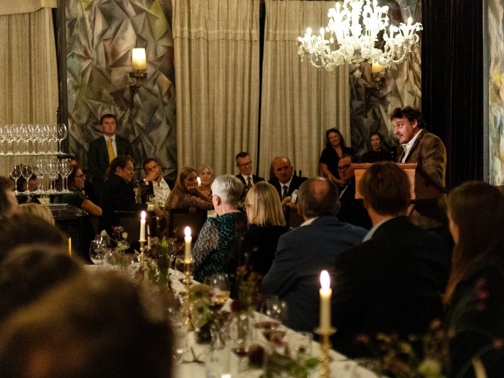 People gathered at a gala dinner while listening to a speaker