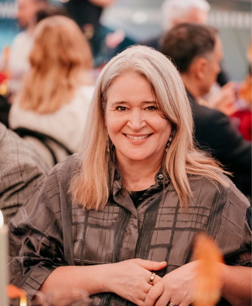 A smiling woman with long blonde hair