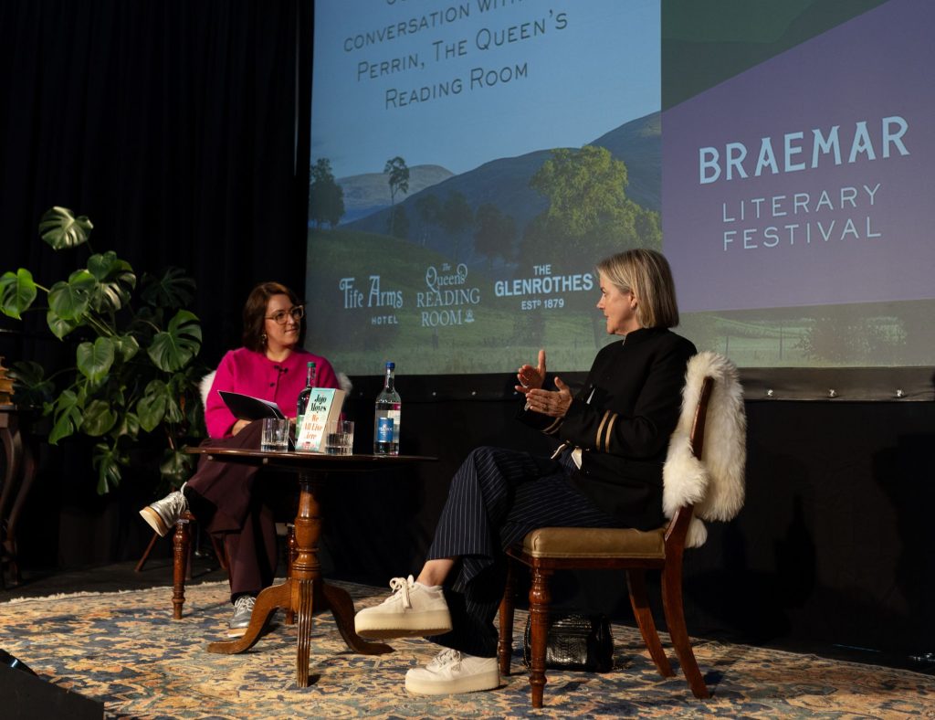 Two women seated and speaking on stage at a literary festival
