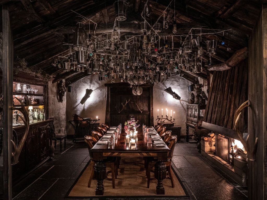 An atmospheric dining room with a large abstract chandelier overhead