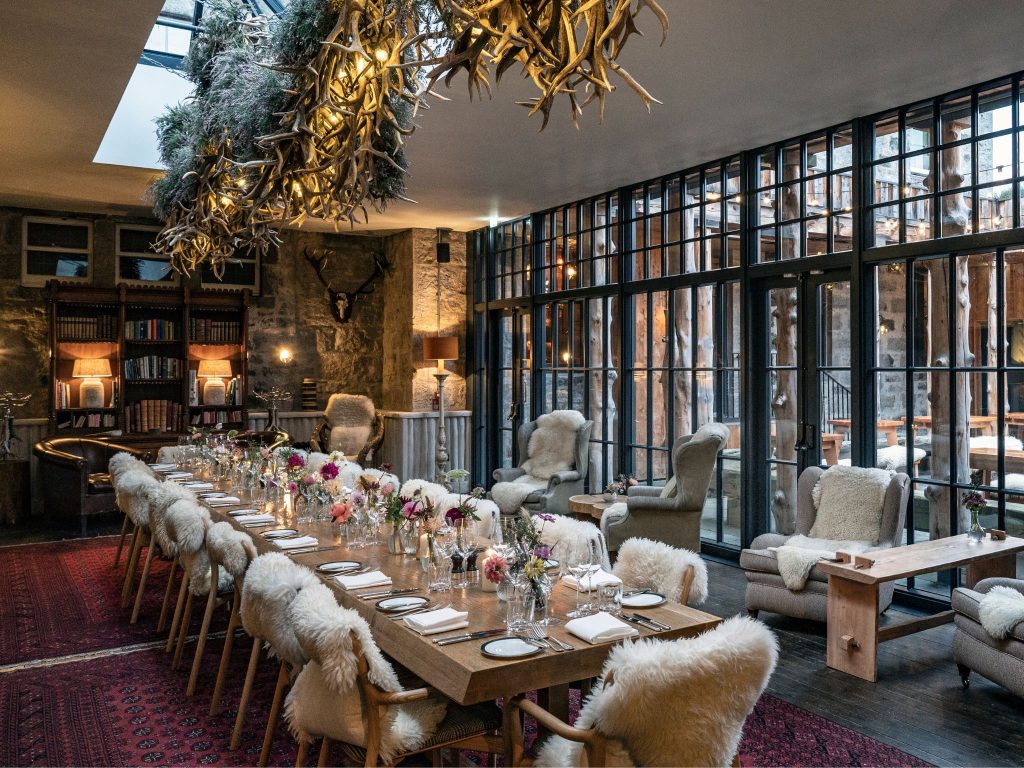 A celebratory dining banquet table beneath a stag horn chandelier
