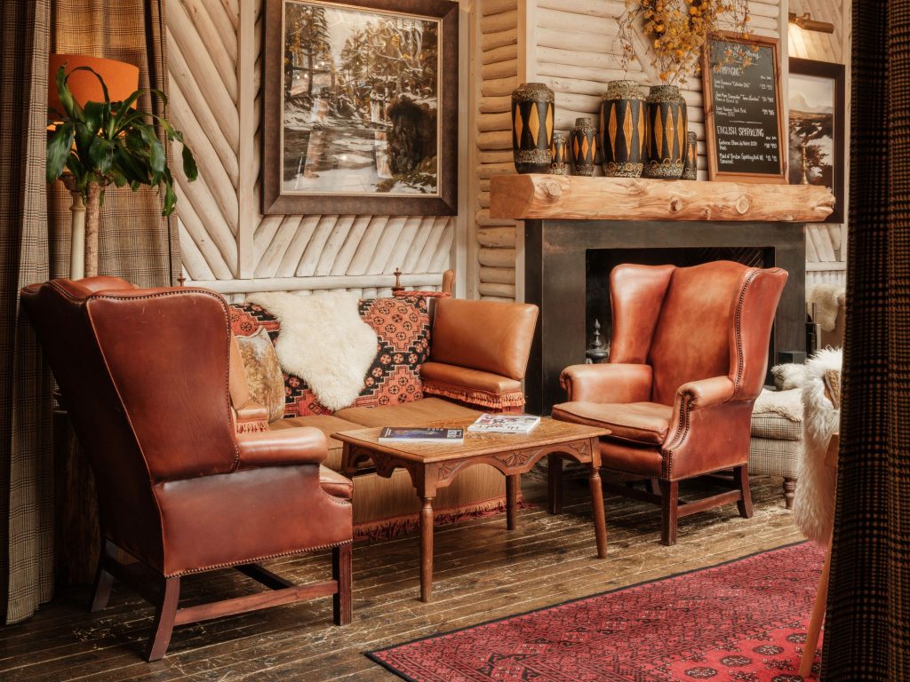 Leather chairs and a sofa beside a fireplace