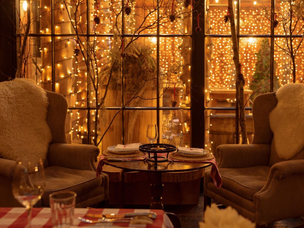 Two armchairs in front of a courtyard with fairy lights