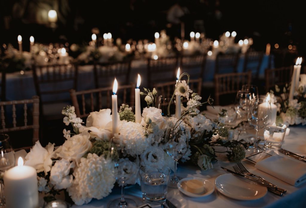 A dining table at a special event set with flowers and candles