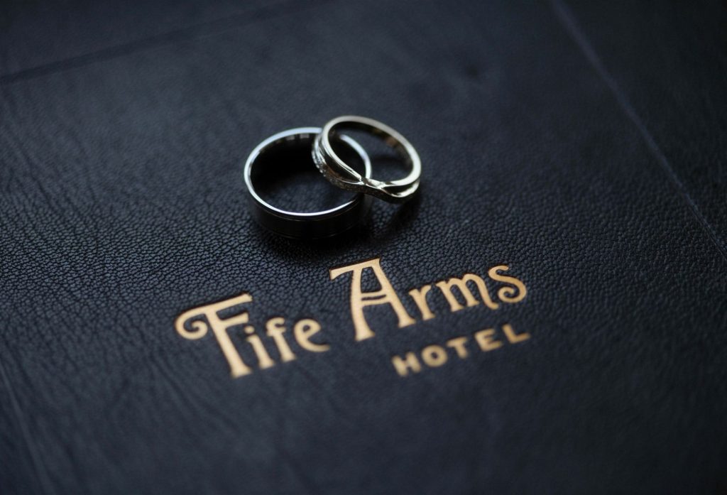 Two wedding rings lying on top of a Fife Arms branded book